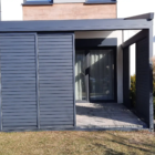 Pergola tkaninowa przyścienna, shuttersy Pergola tkaninowa przyścienna o wymiarach 4,5 × 3 m, Konstrukcja w kolorze antracyt (zbliżony do RAL 7016), Całość uzupełnia zabudowa boczna shuttersy. Materiałowy dach z wodoodpornej tkaniny DRIPLUX – szary na zewnątrz i jaśniejszy od środka, Dach jest sterowany elektrycznie systemem SOMFY. Spin Szczecin